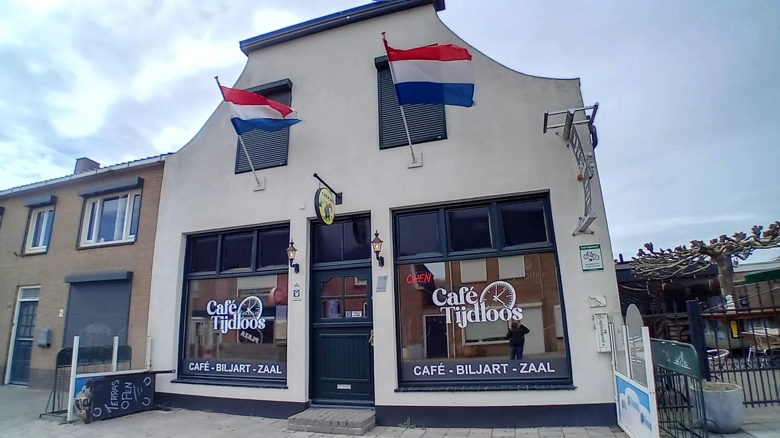 De gevel van Café Tijdloos aan de Molenstraat met de vlaggen uit